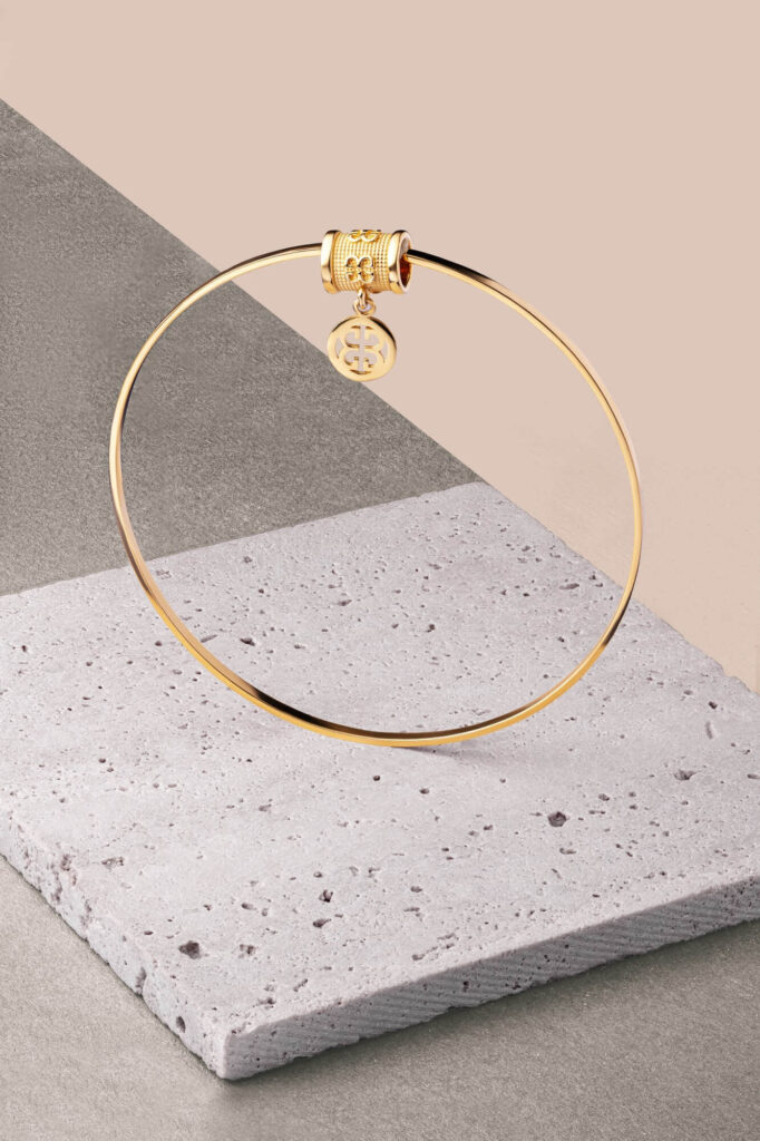 Złota bransoletka twarda z elementem ozdobnym z wisiorkiem