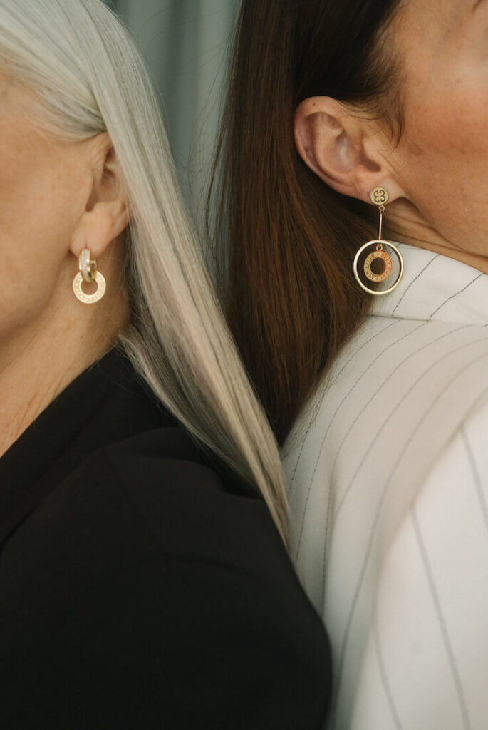 Sylwetki dwóch kobiet ze złotymi kolczykami Belleway