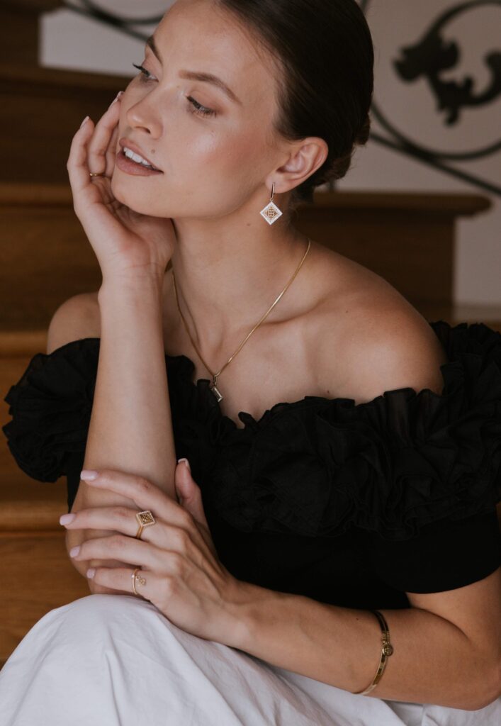 Złota biżuteria Belleway na elegancko ubranej kobiecie