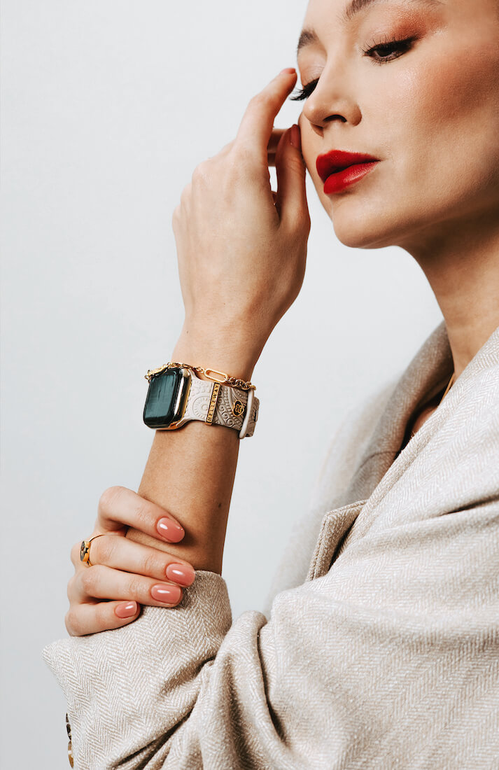 Kobieta w młodym wieku z widocznym smartwatchem na ręce i złotymi dodatkami marki Belleway