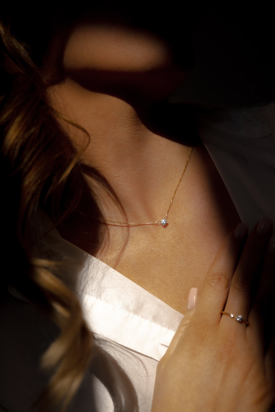 Sylwetka kobiety ze złotym naszyjnikiem i złotym pierścionkiem oraz z diamentami - produkcji jubilera Belleway